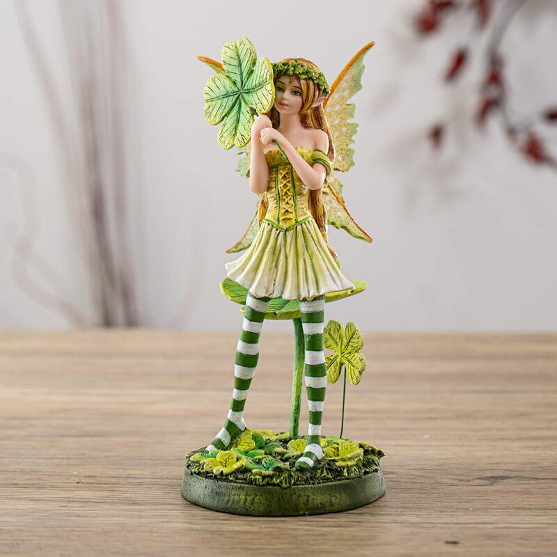 Figurine of a fairy wearing a green dress with four leaf clovers and striped stockings