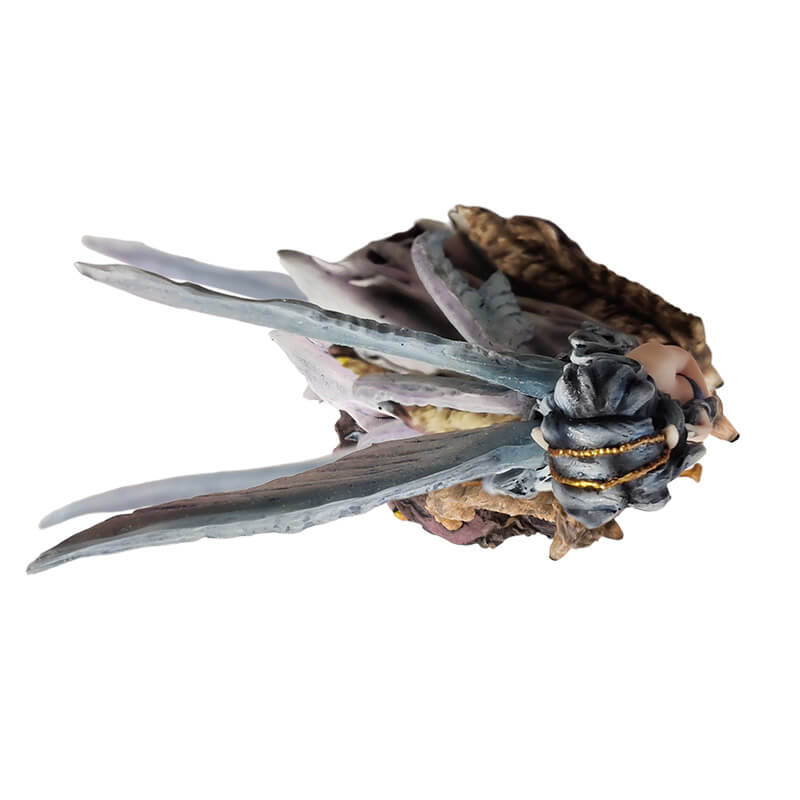 Figurine of fairy with gray wings and hair and purple dress walking with two tan wolves. Fae carries a gold wand. Top down view