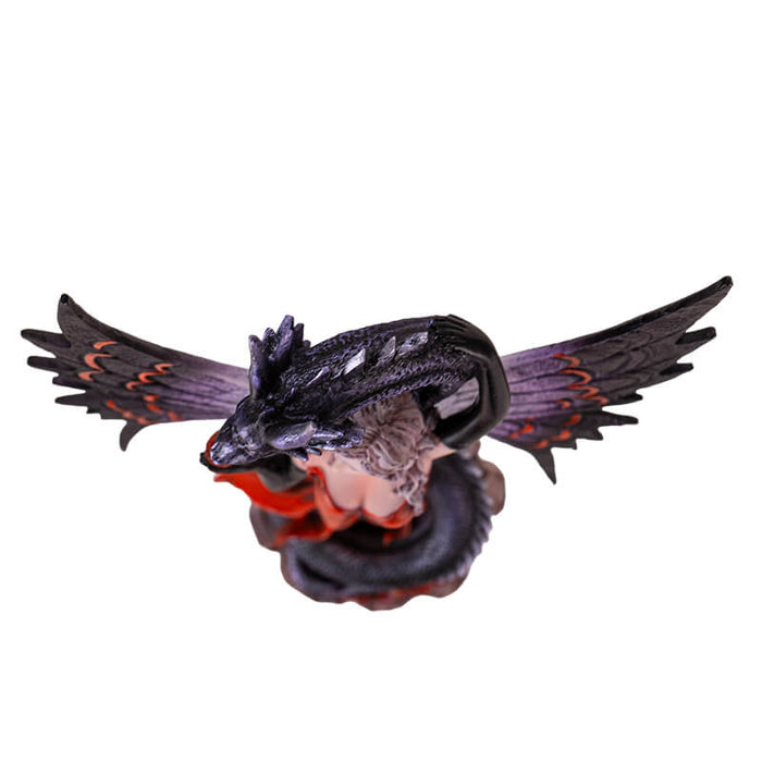 Figurine of fairy in black and red holding a rose, with a black snake dragon wrapped around her protectively. Top down view