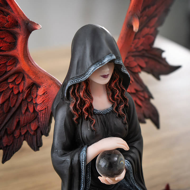 Closeup of angel's red wings and hair, black hooded cloak, holding crystal ball