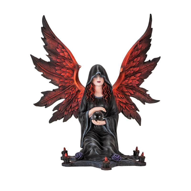 Figurine of an angel with red wings and hair in a black cloak, holding a crystal ball sitting at the center of a star with purple roses and candles