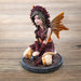 Figurine of fairy in red and orange with lion mane and tail, sitting with gem clusters in yellow and crystal ball
