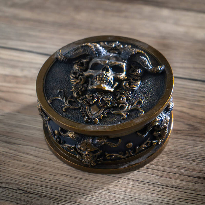 Trinket box with gold horned skulls on black background