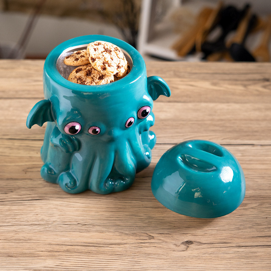 Ceramic cookie jar in teal, pink eyed, tentacled Cthulhu monster shaped, shown with lid off, full of cookies