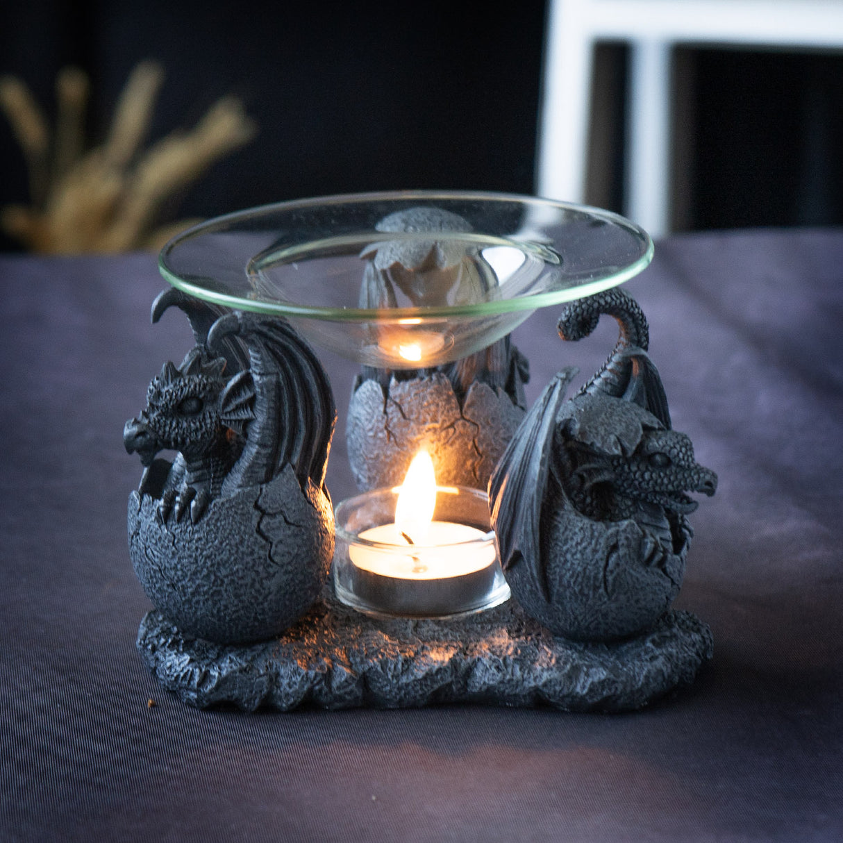 trio of dragon hatchlings in faux stone holding up glass dish, oil burner, shown lit