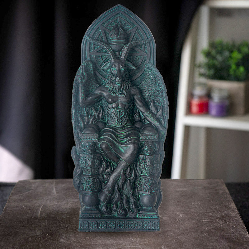 Figurine in dark teal faux-stone of seated Baphomet on throne with goat face, antlers, cloven hooves, symbols surrounding him