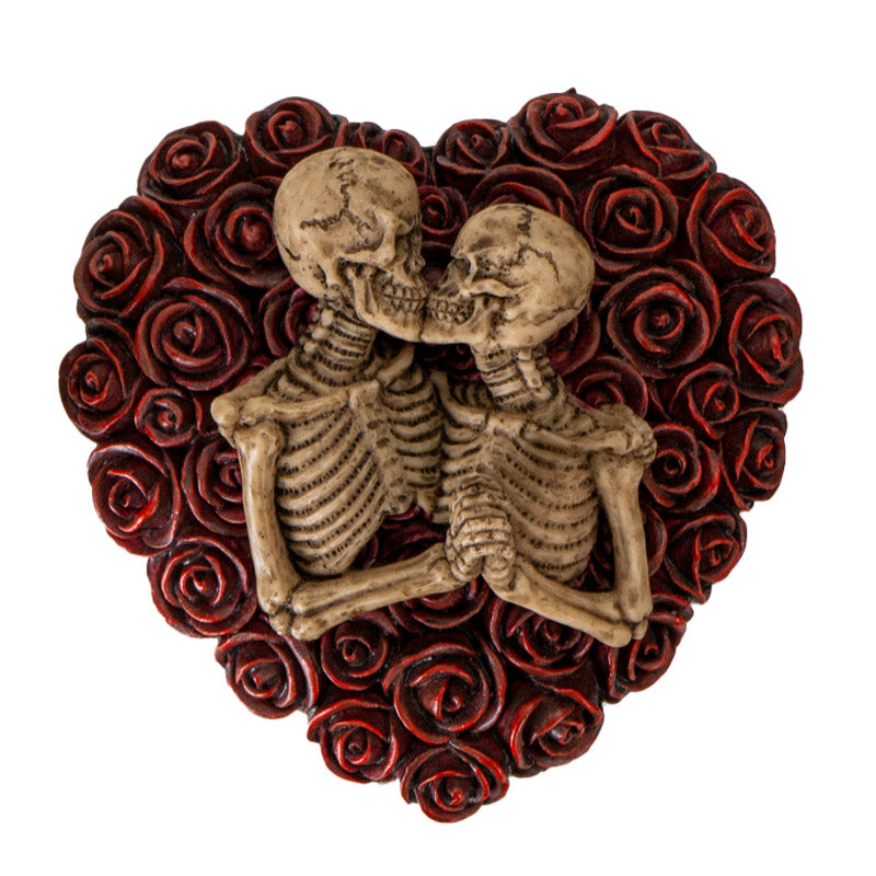 Trinket box shaped like a heart covered in red roses, pair of skeletons kissing on the lid