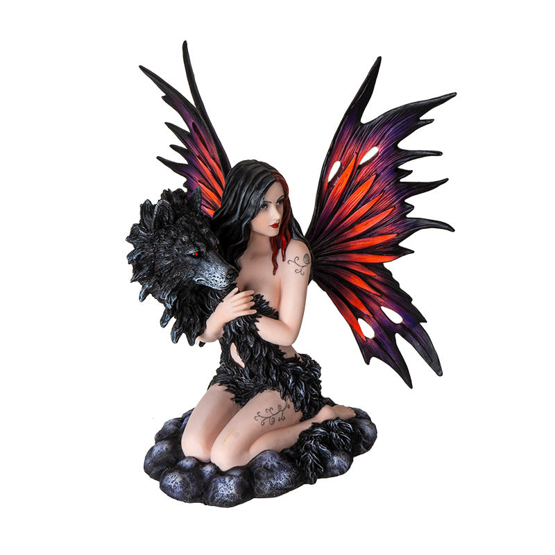 Figurine of fairy with red and purple wings kneeling on stone, black wolf face with fur wrapping around the tattooed pixie