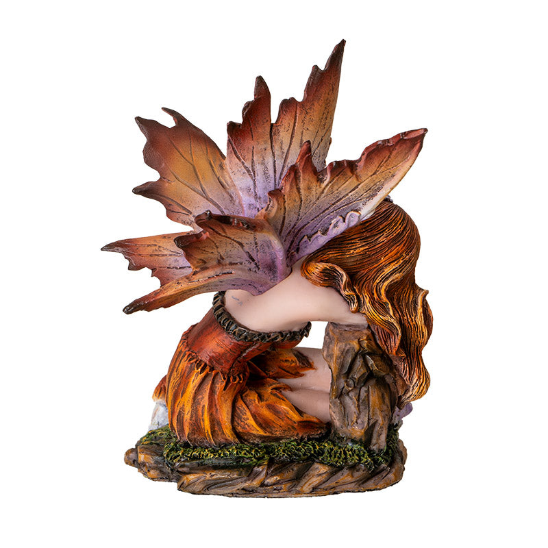 Fairy figurine, brown-orange dress, hair, wings, sleeping on a stump