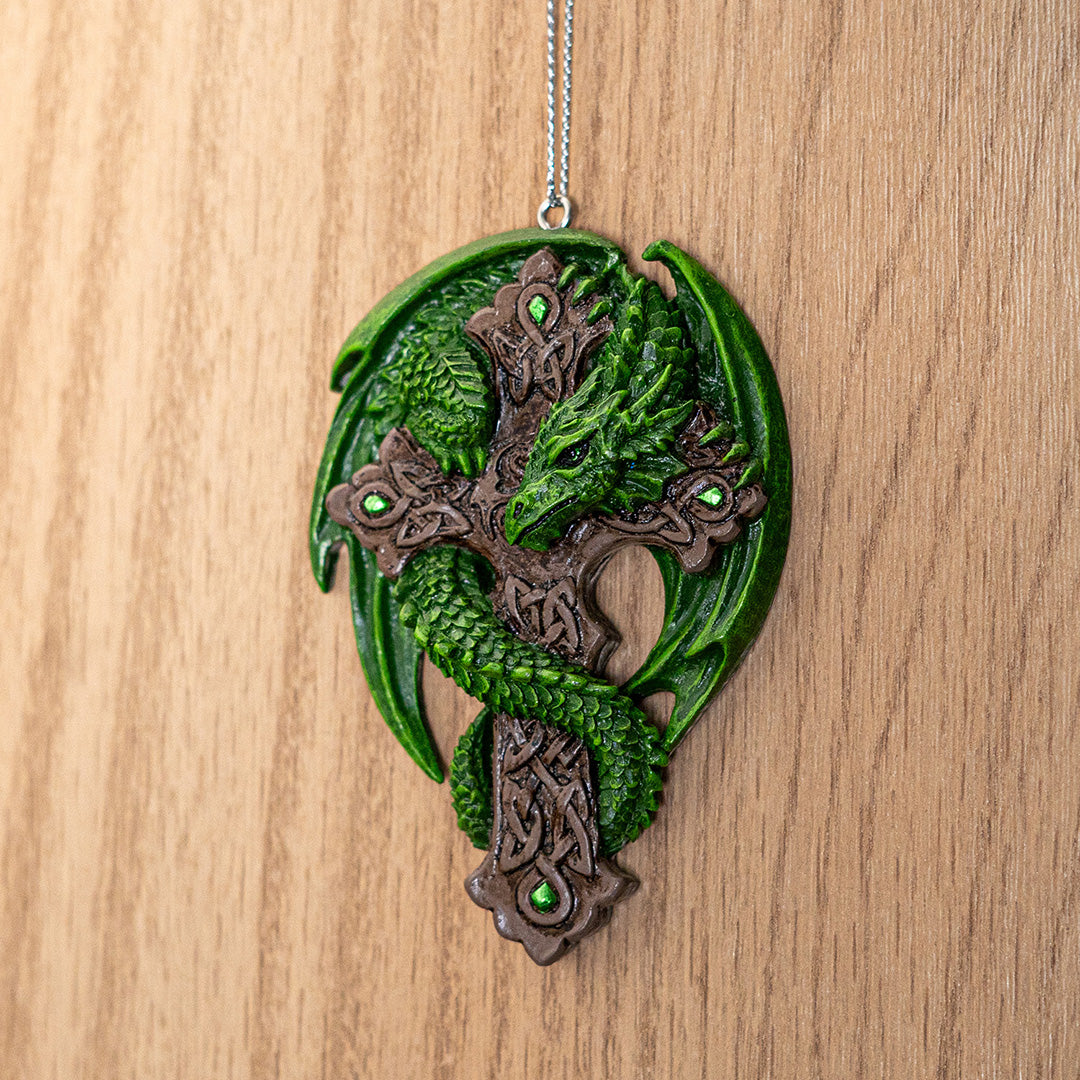 Ornament of green dragon curled around brown Celtic cross with knotwork