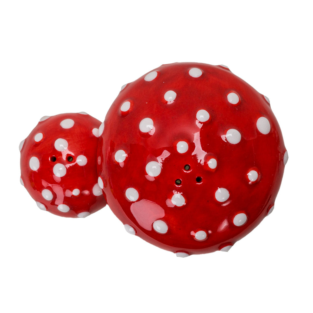 Pair of salt and pepper shakers shaped like red and white fly agaric (amanita) mushrooms. Shown top down