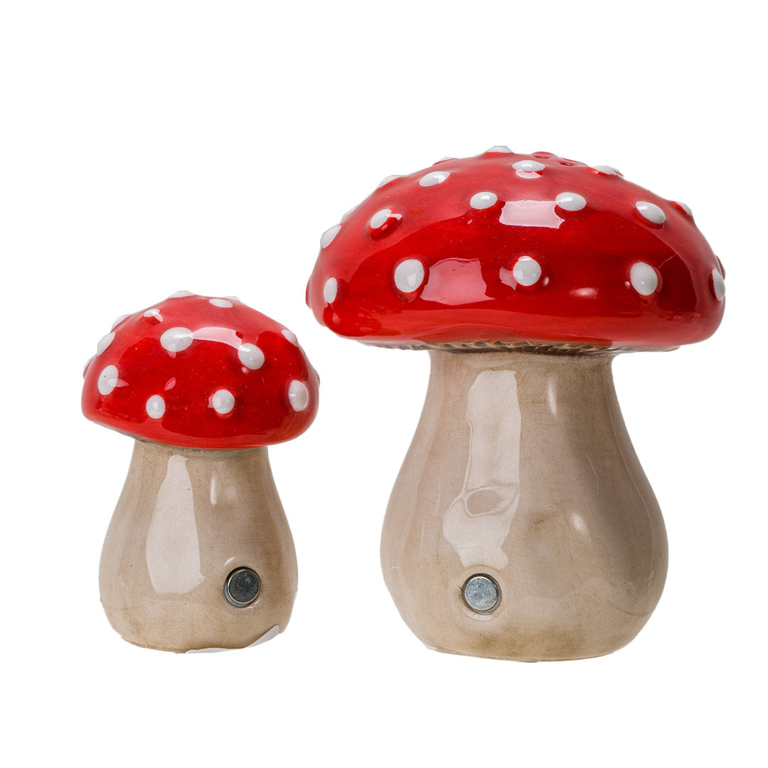 Pair of salt and pepper shakers shaped like red and white fly agaric (amanita) mushrooms. Showing magnets on them