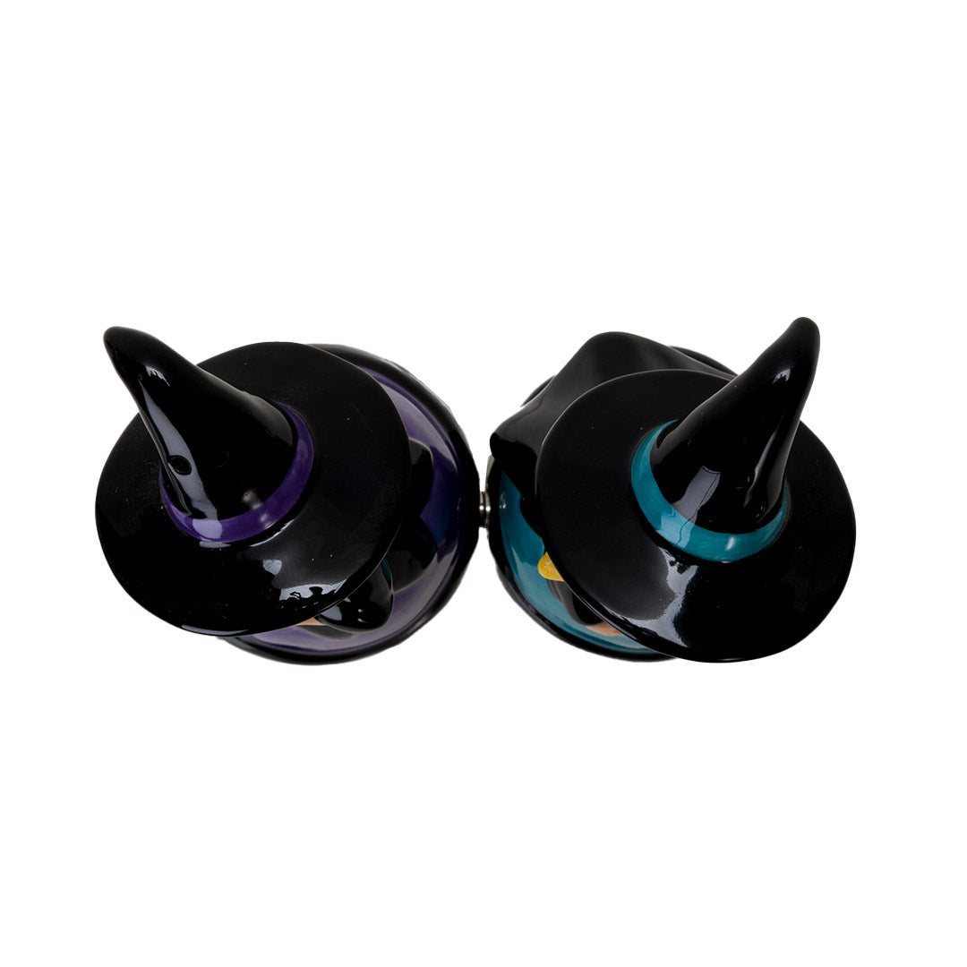 Salt & Pepper shakers shaped like witches in black hats and dresses. One accented in purple holding a broom, the other with blue accents holding a star wand. Shown from the top down