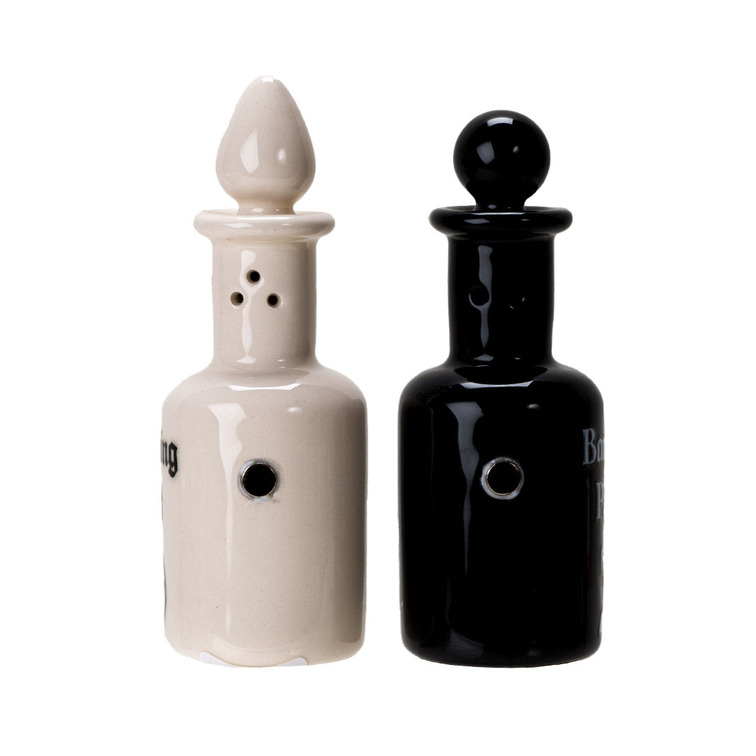 Salt and pepper shakers shaped like potion bottles. White one reads "Purifying Salt" and black one has "Banishing Pepper" with arcane symbols, attached via magnets to one another