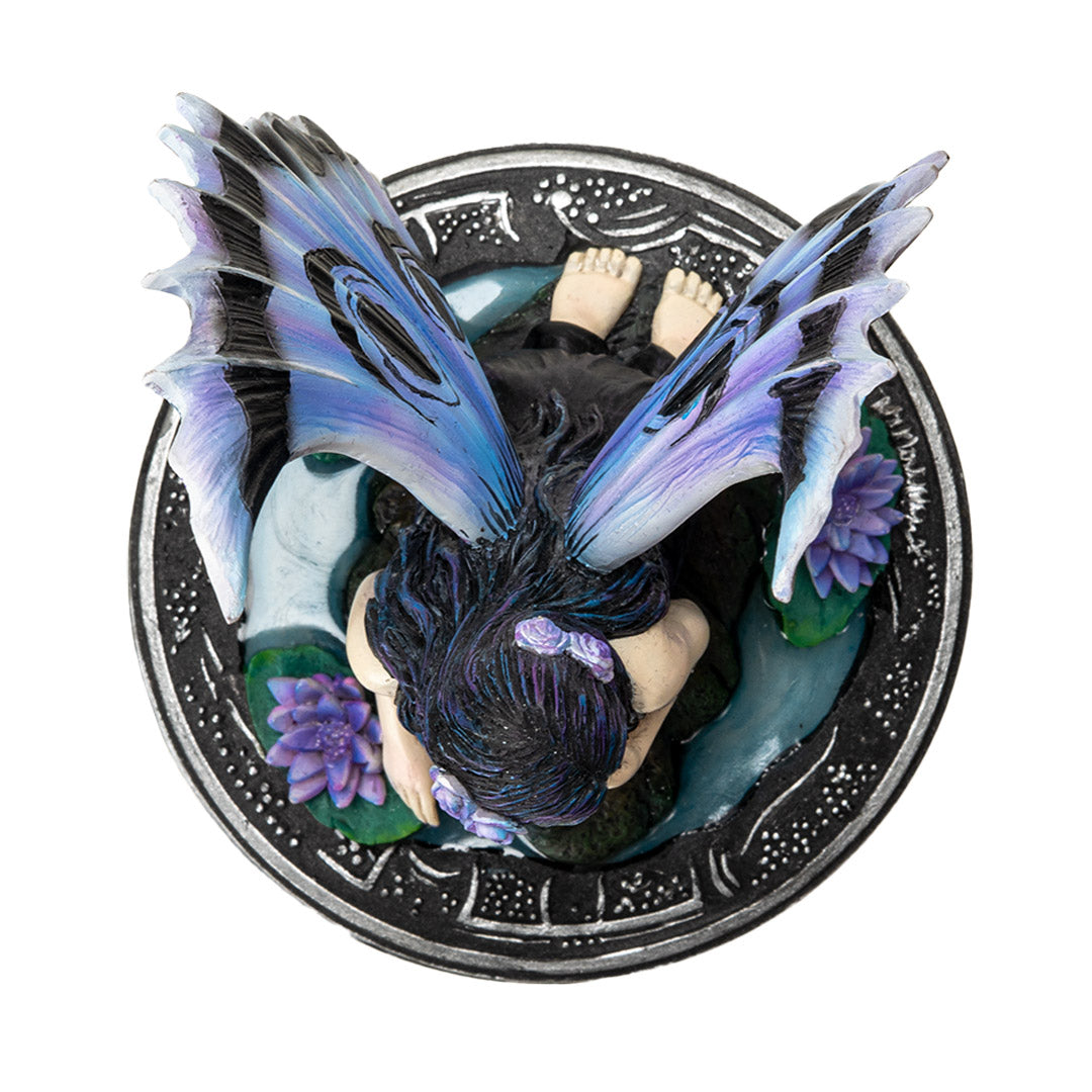Trinket box with black base and silver designs. On the lid is a fairy in black dress with purple and blue wings accented in black, sitting amidst water lilies. Shown top down