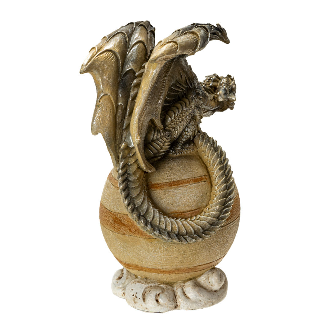 Figurine of a brown dragon perched upon the tan planet Saturn on a cloud base, shown from the back