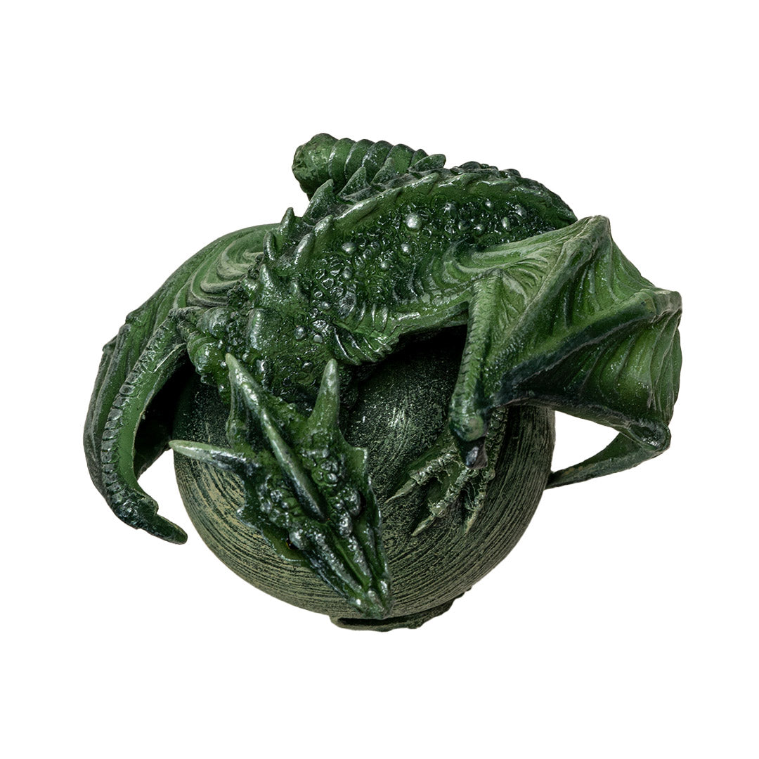 Figurine of a green dragon with open mouth and scorpion tail curled around a light green planet on a rocky base, shown top down