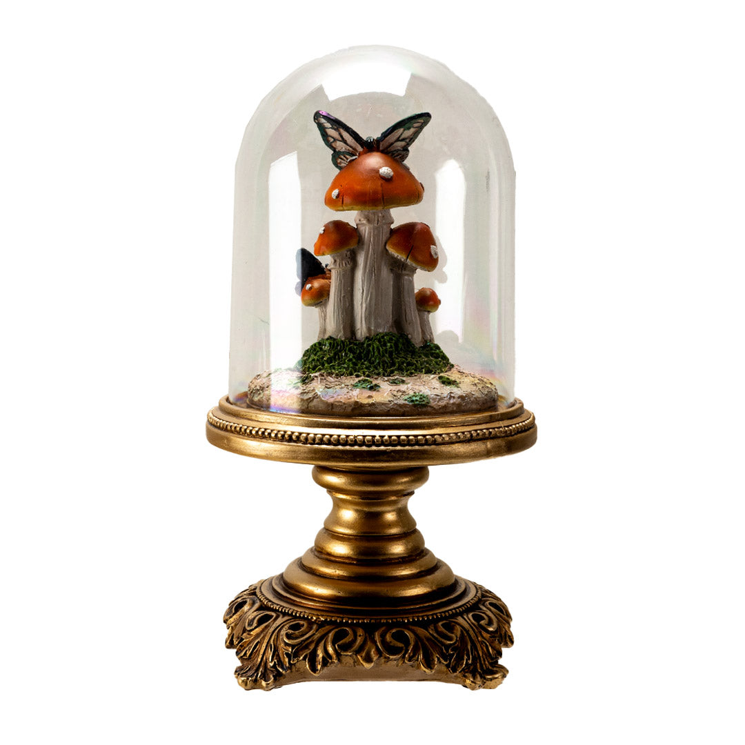 Figurine of butterflies on orange-red mushrooms underneath the glass dome of a cloche, on an ornate golden base