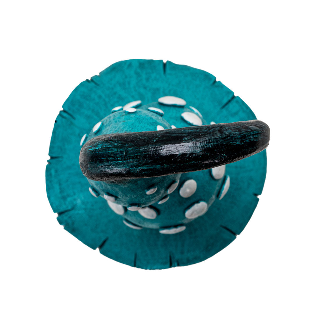 Figurine of tall mushroom with blue cap (white spots on it ) and tan stem, shown top-down