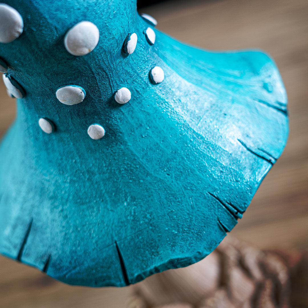 Closeup of blue mushroom cap with white spots