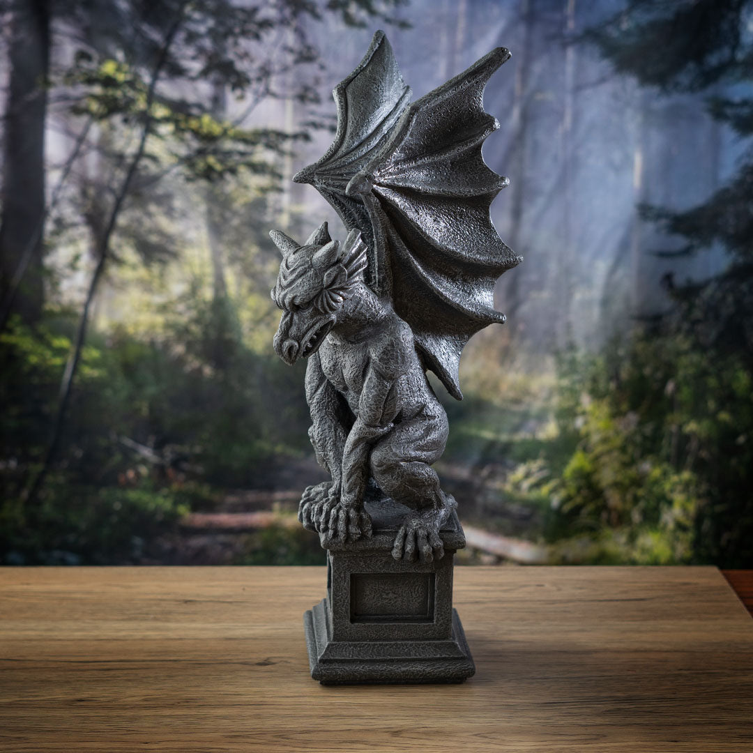 Figurine of a gray faux-stone gargoyle with dragon wings perched on a column