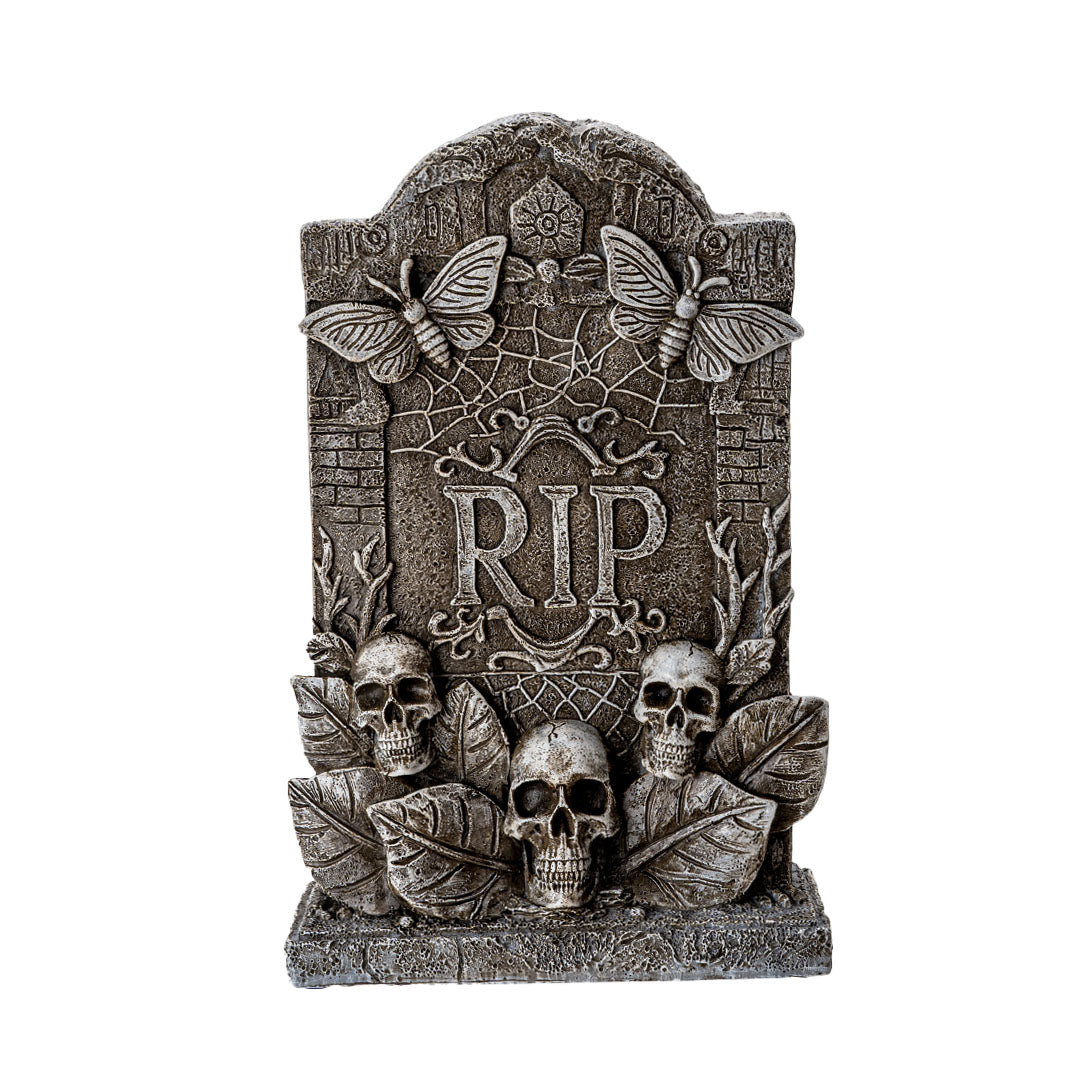 Figurine of gray faux-stone tombstone with butterflies, RIP, skulls and leaves