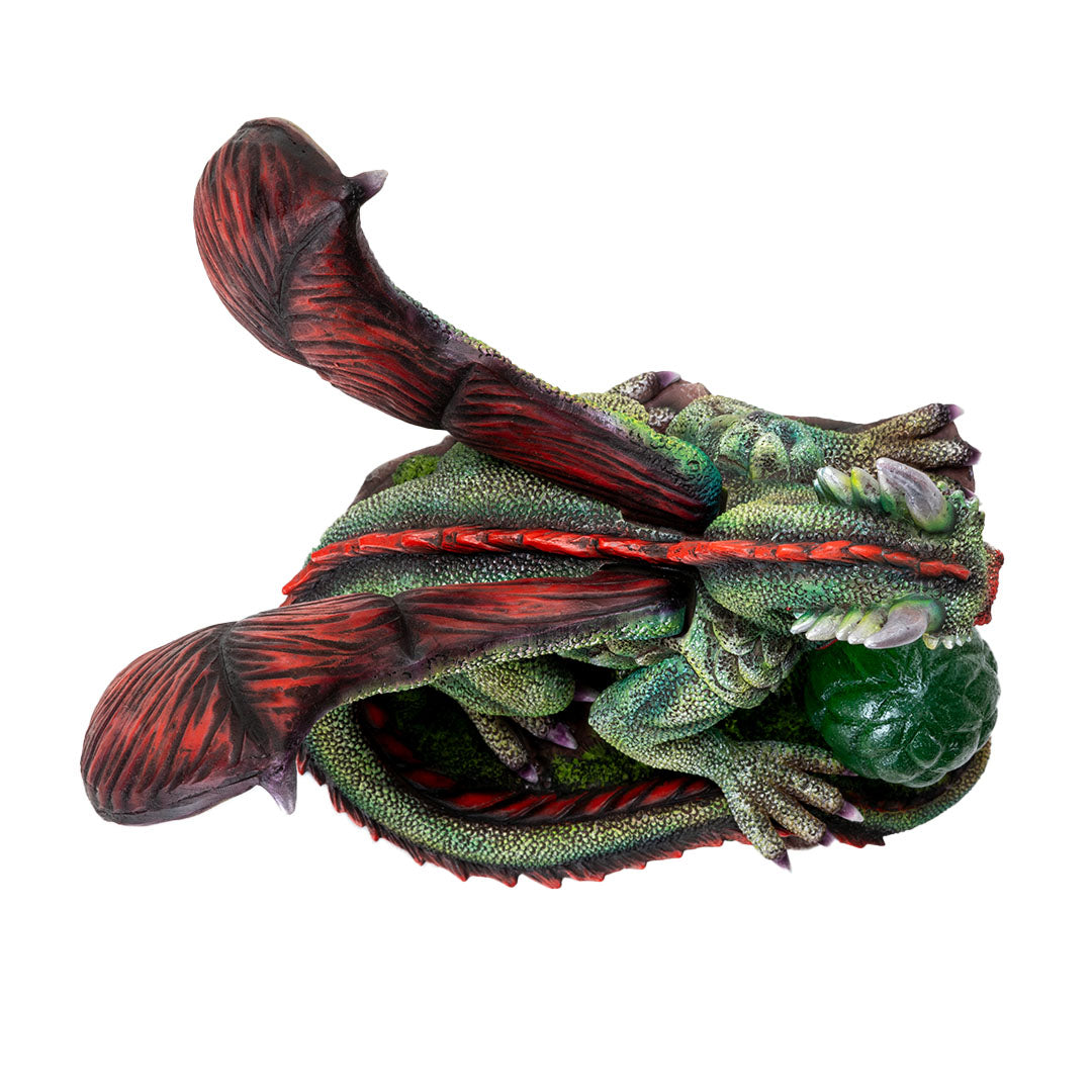 Figurine of green dragon with red wings, spines, eyes and belly, with an egg in front that can glow with LED lighting, top down view