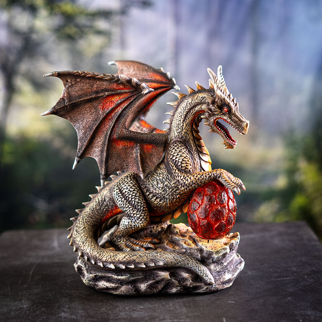 Figurine of coppery dragon with red accents holding a crimson egg (LED)