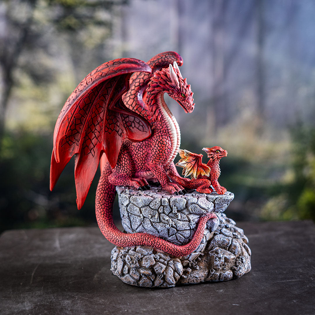 Figurine of red dragon parent with baby hatchling on rocky pedestal