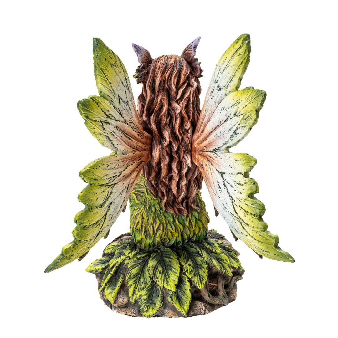 Figurine of pale fairy with brown hair, green dress and wings sitting amidst leaves, shown from the back