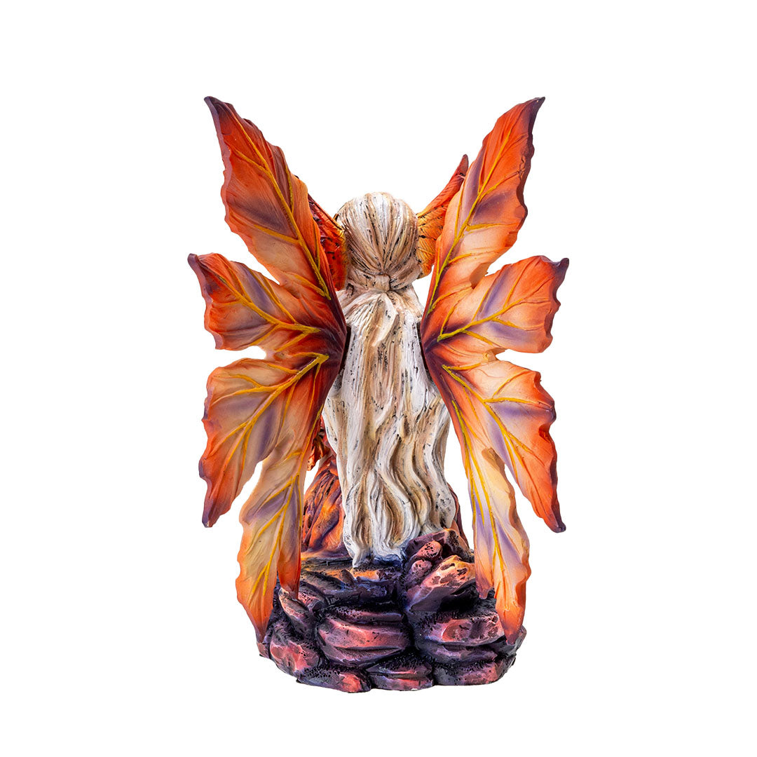 Figurine of blond fairy with orang wings and outfit sitting on a rock. Shown from the back, long pale hair, leaf-like wings