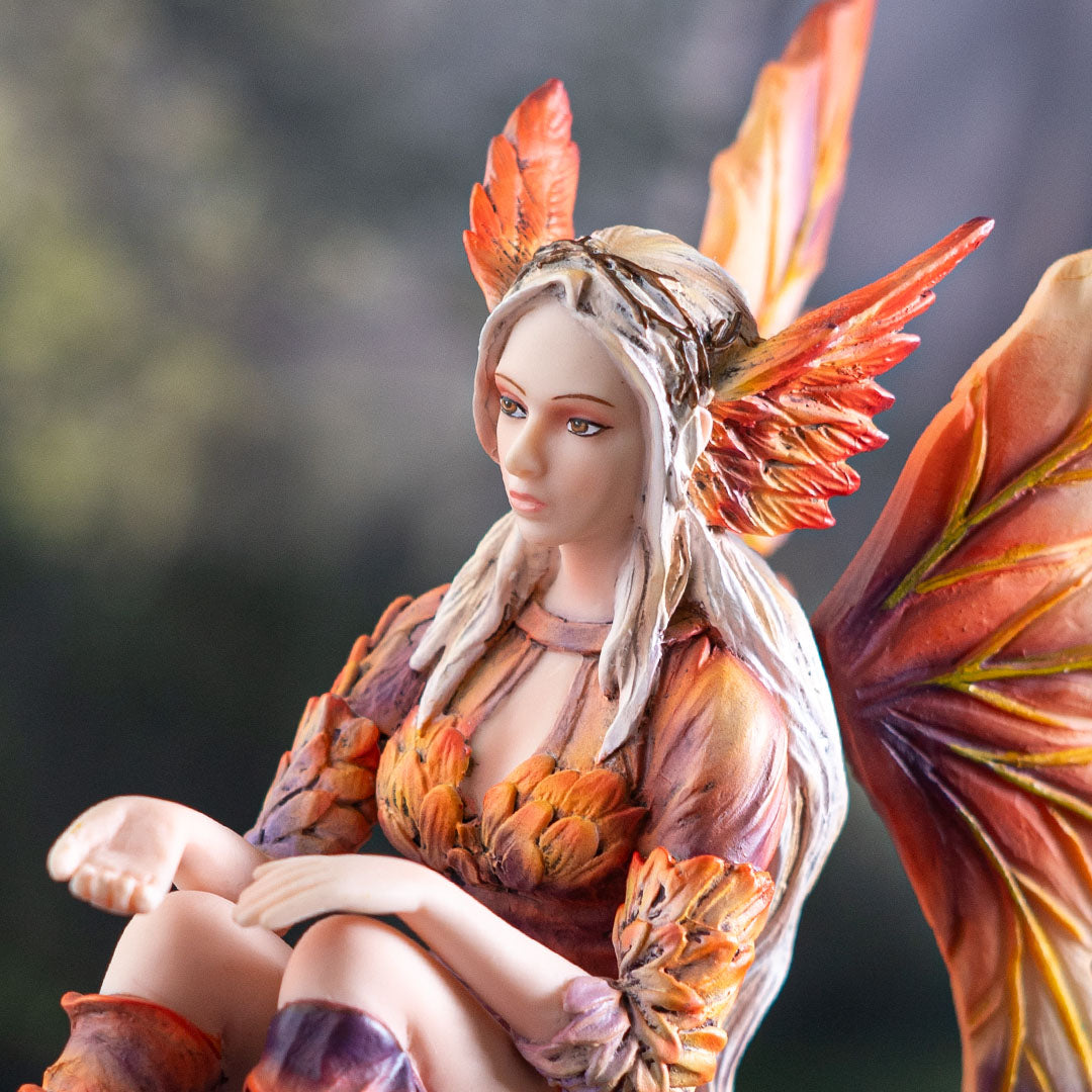 Closeup of fairy with red feather wings on side of her head, petal dress in orange shades, hand out