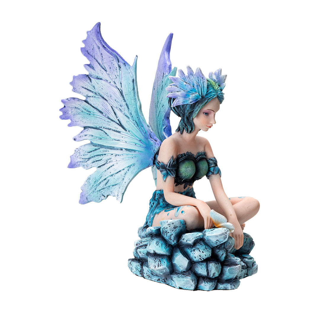 Figurine of a sitting fairy, blue-purple wings and green-blue hair, sitting on rocks with a butterfly