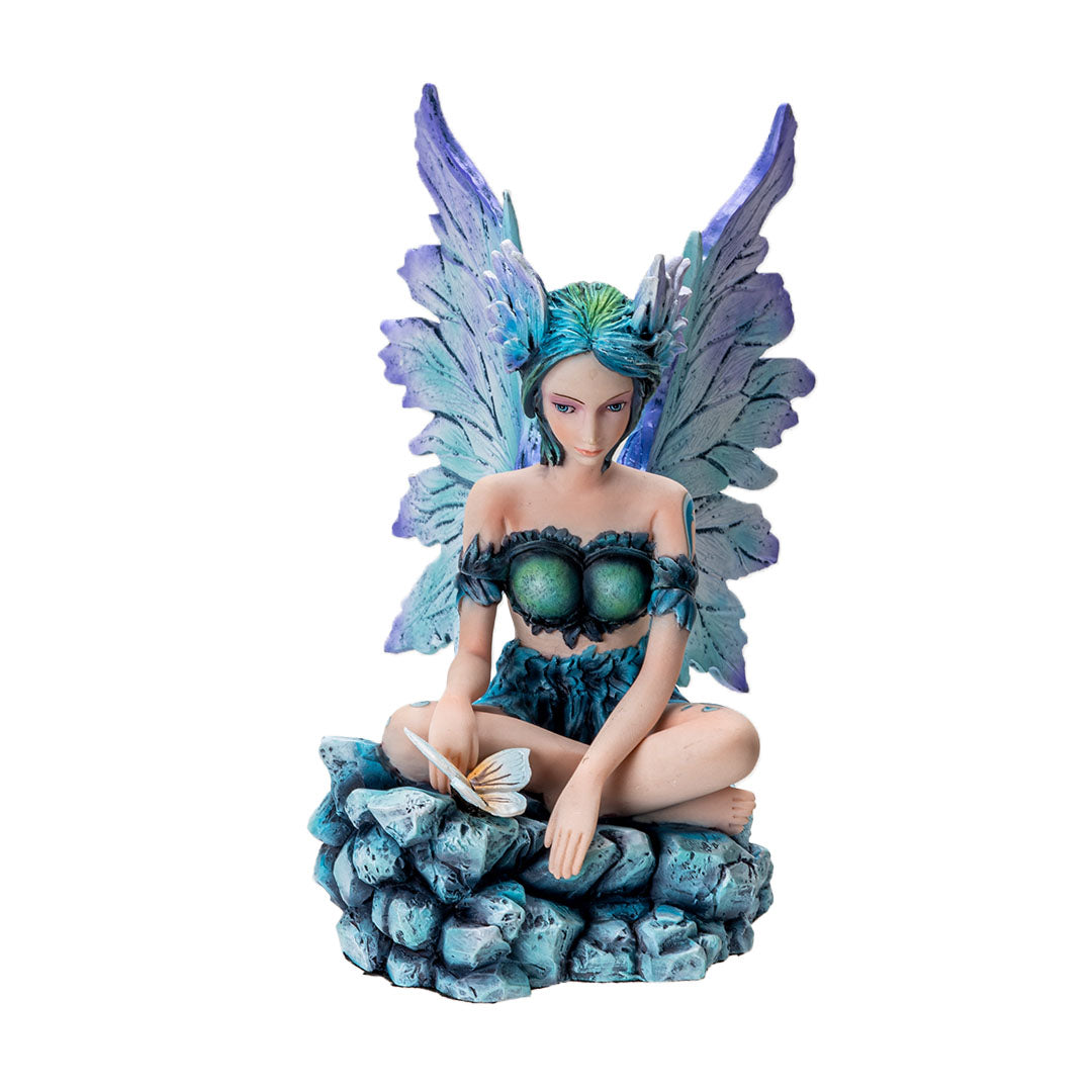 Figurine of a sitting fairy, blue-purple wings and green-blue hair, sitting on rocks with a butterfly