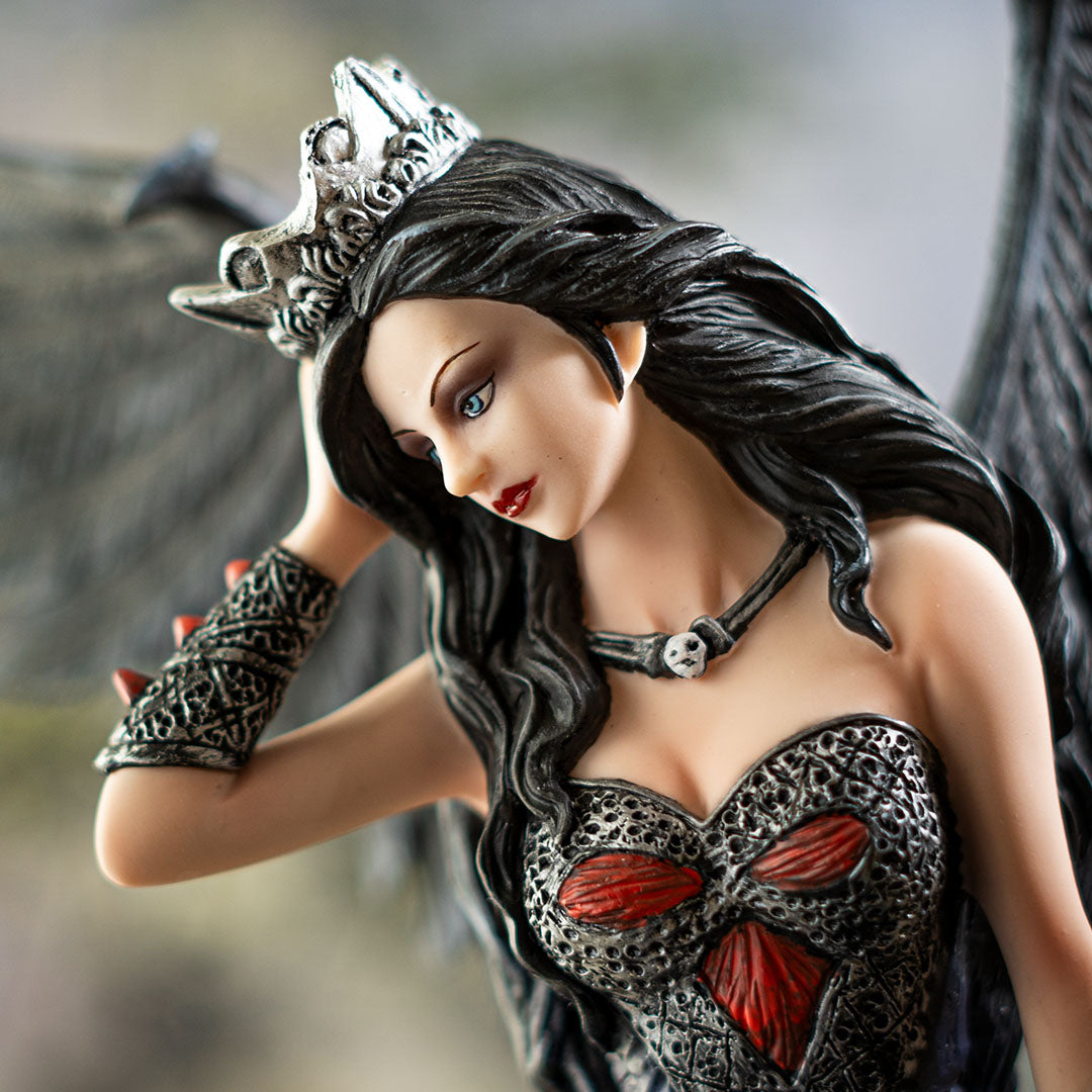 Closeup of gothic fairy queen - pale skin, black hair, silver crown, arm guards, black corset top with red accents