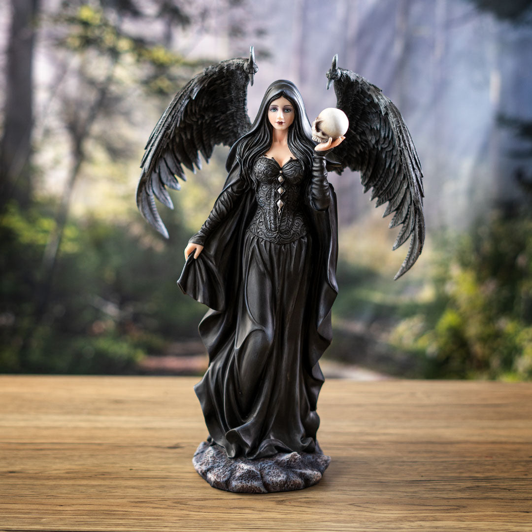 Figurine of black feather-winged angel lady in black cloak holding a skull
