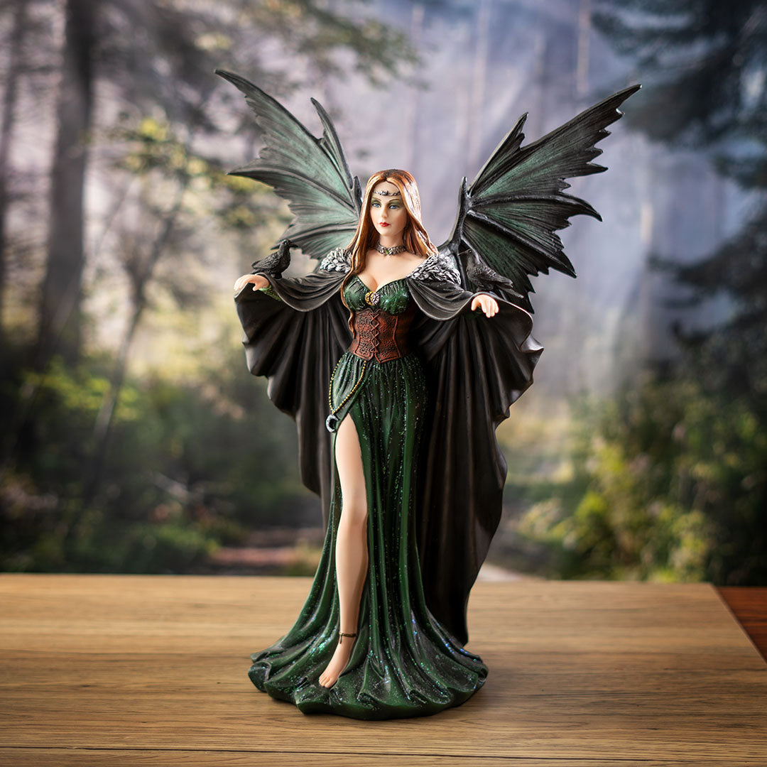Figurine of fairy woman with brunette hair, green-black wings, emerald dress with red corset, raven on each hand