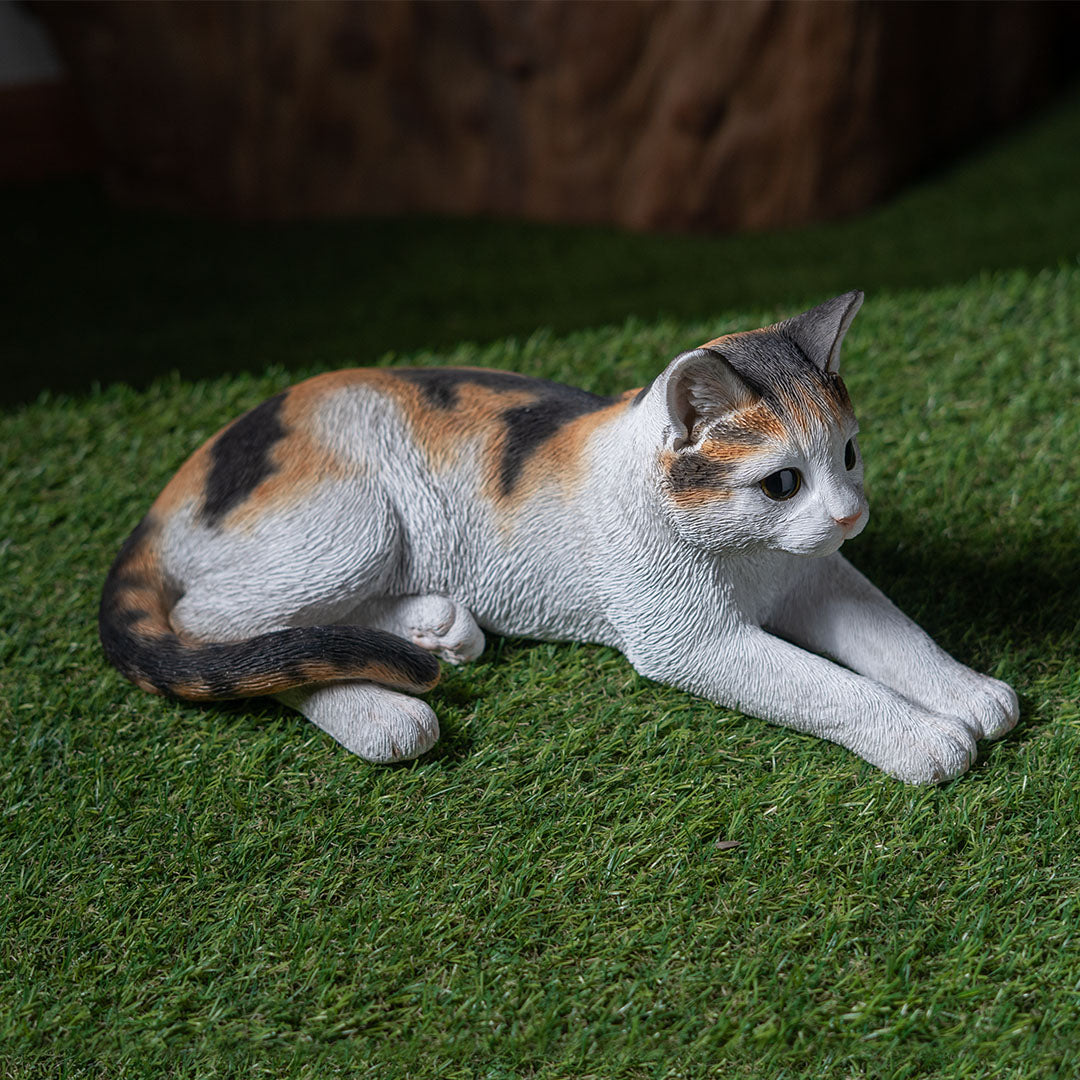 Calico cat figurine, lying down pose