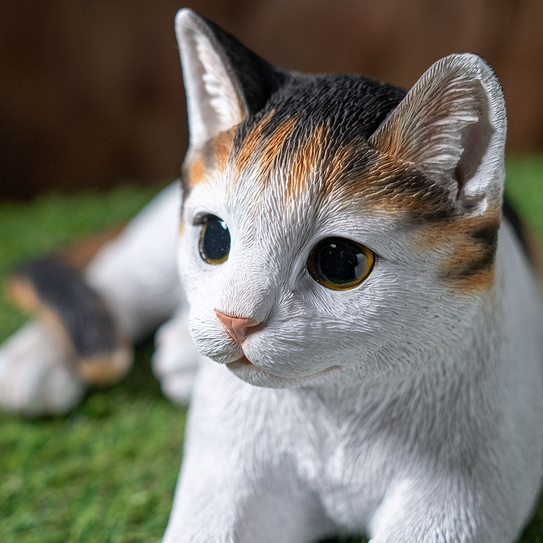 Calico cat figurine, lying down pose