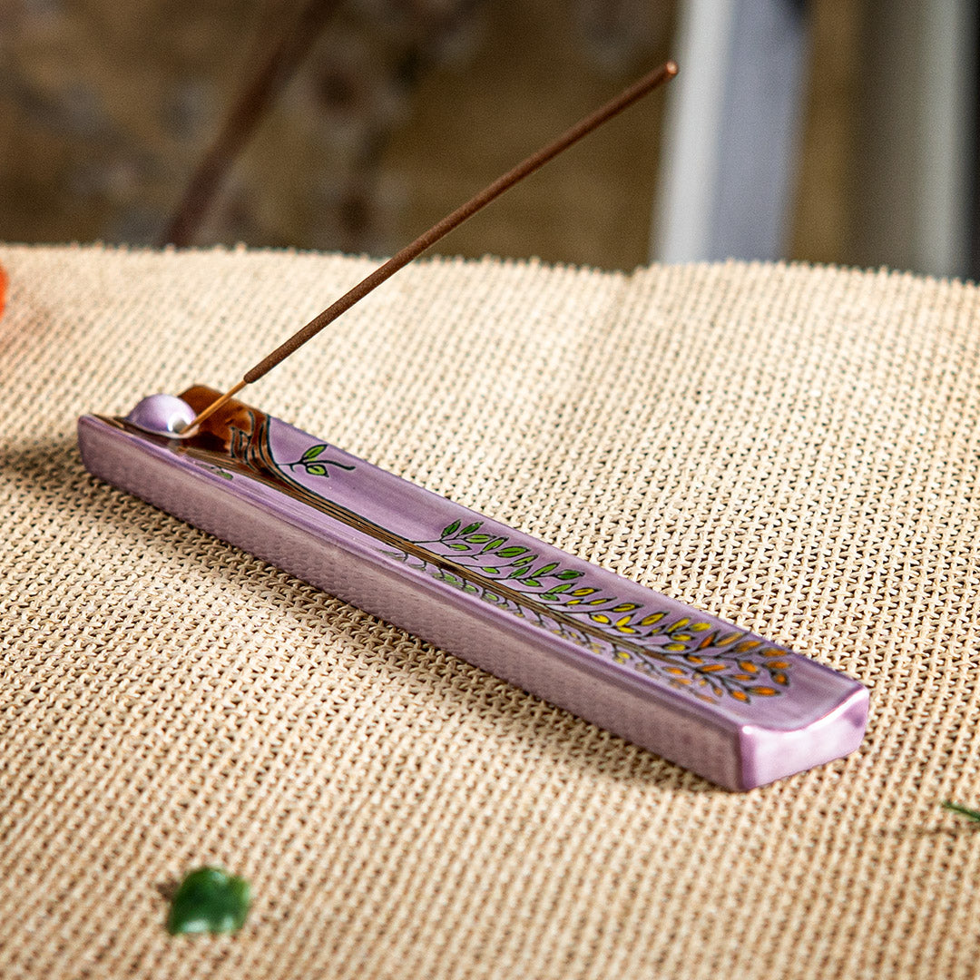 Purple ceramic incense burner with tree of life design painted on, leaves in orange, yellow and green