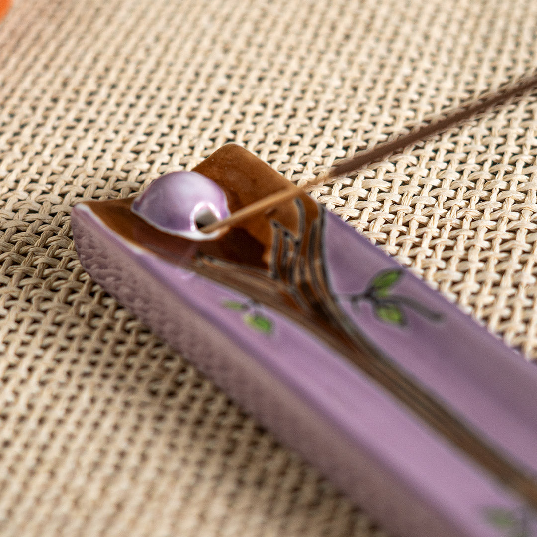 Purple ceramic incense burner with tree of life design painted on, leaves in orange, yellow and green