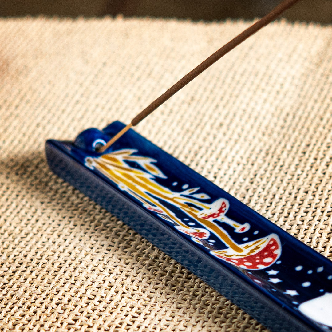 Blue ceramic incense holder with red and white mushrooms painted on under a full moon