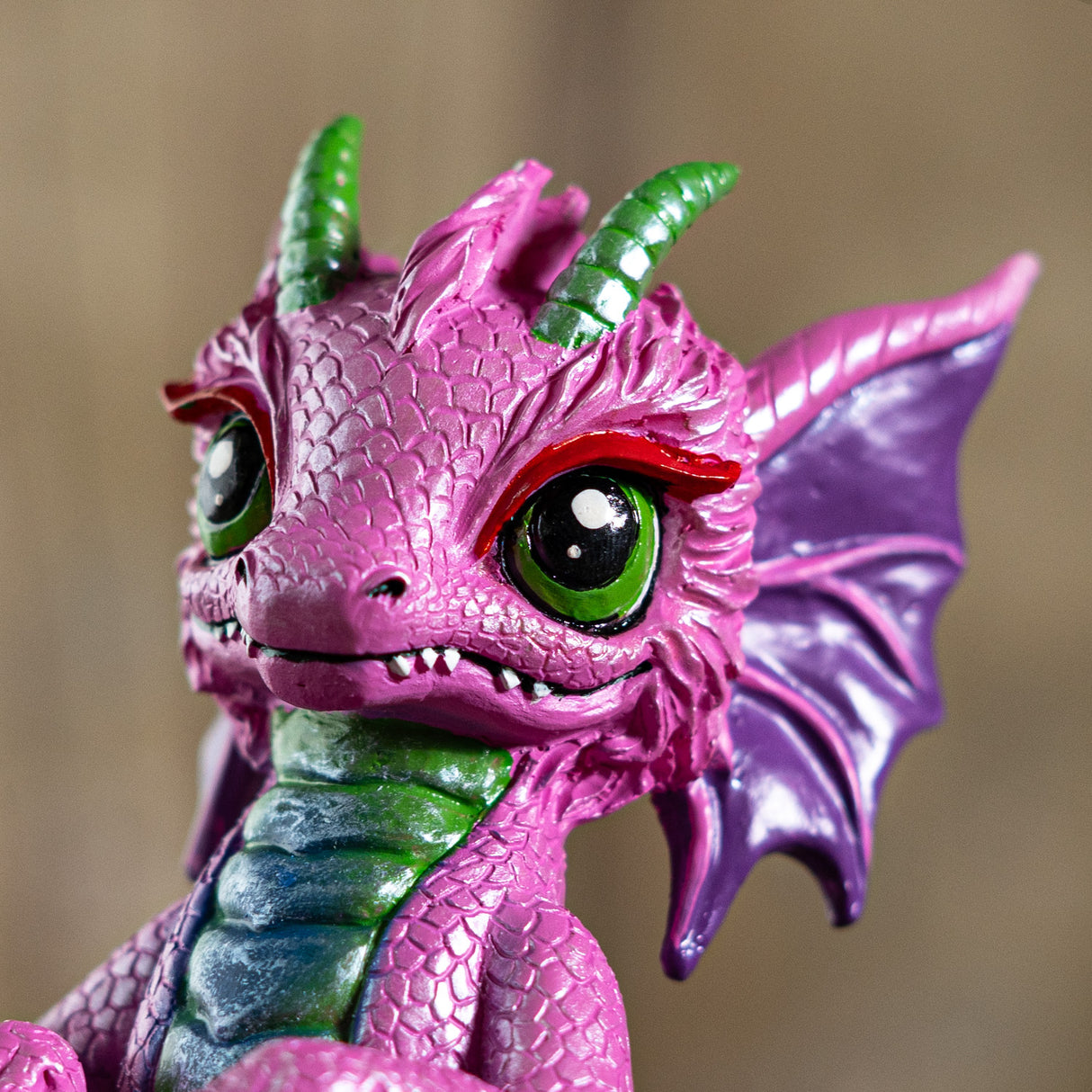 Close-up of a pink and green dragon figurine