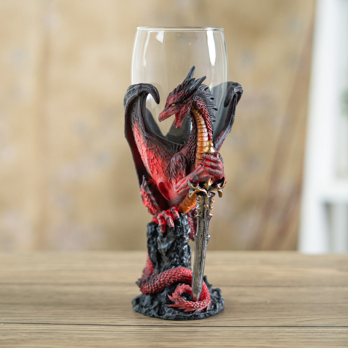 Glass goblet with red, black and gold dragon holding sword