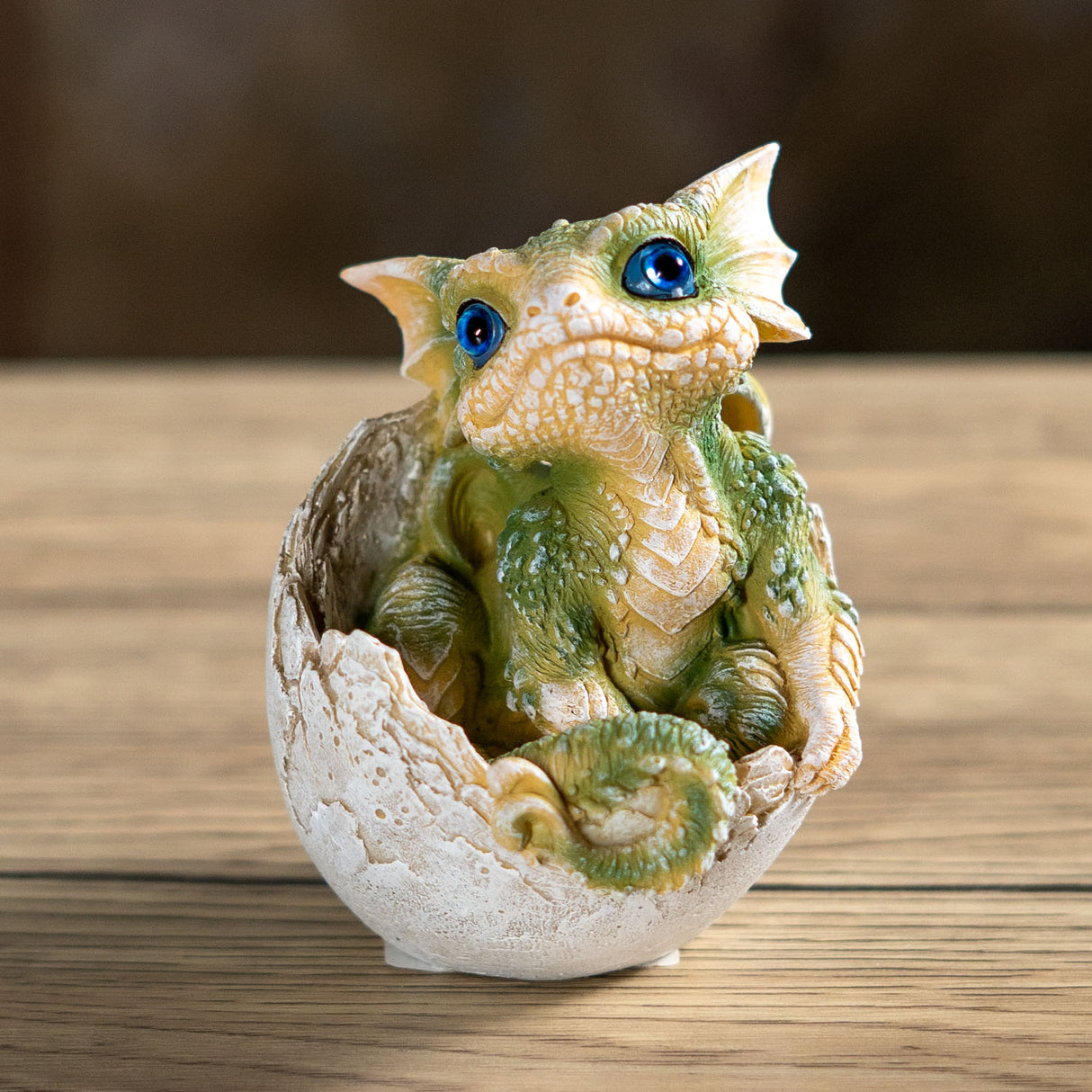 Green baby dragon emerging from an egg