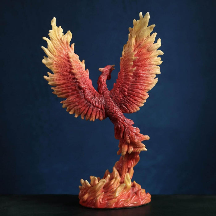 Figurine of a red, orange and yellow firebird rising from the flames