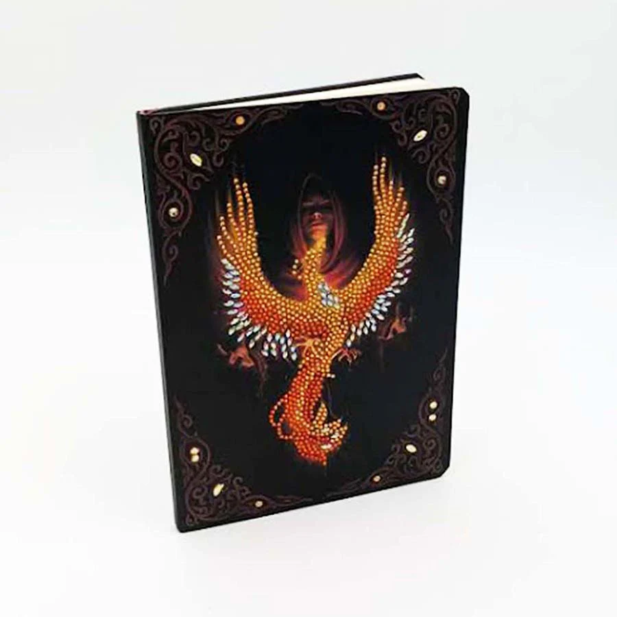 Crystal art notebook cover with orange and red firebird rising with gem accents, woman in back in the darkness
