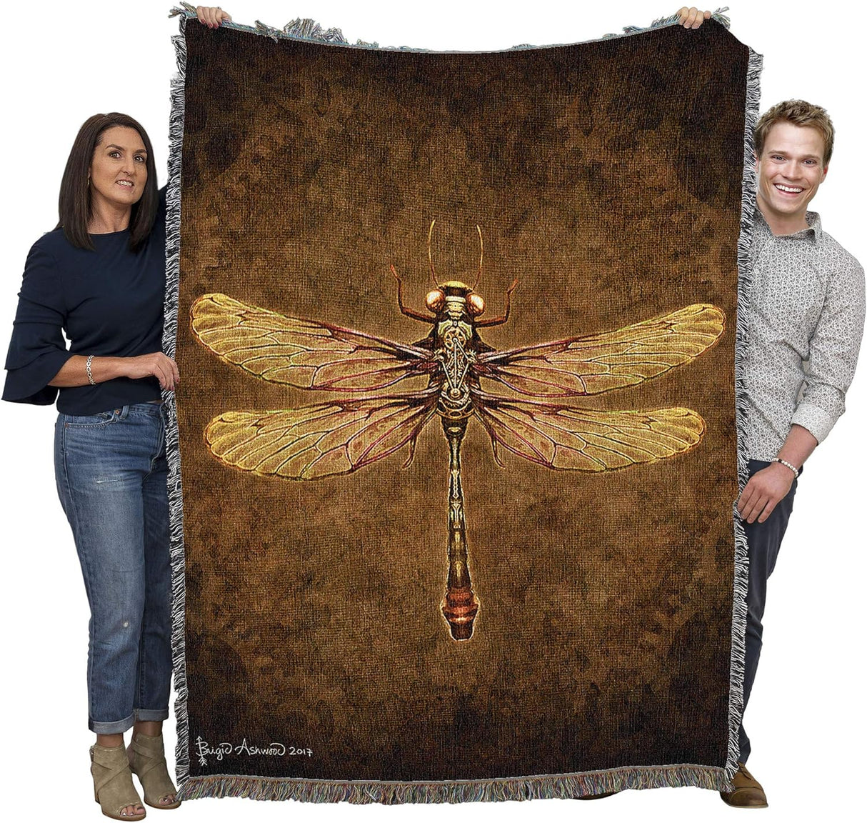 Woven tapestry blanket with Steampunk Dragonfly artwork on a textured brown background. Held up by two adults to show large size
