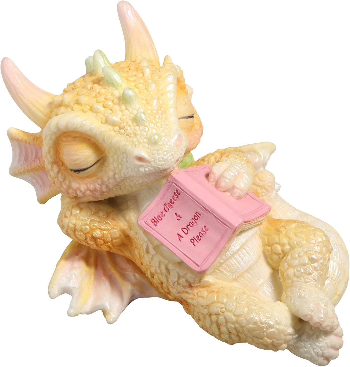 Cute sleeping dragon figurine holding a pink book