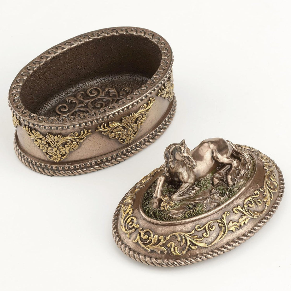 Decorative metal box with intricate designs and a horse figure on the lid